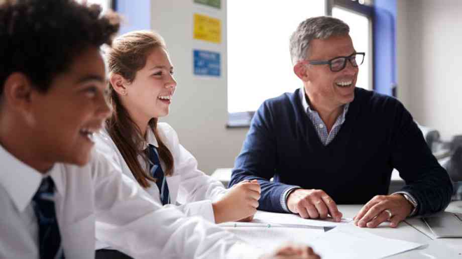 Teacher assists his students with their work.