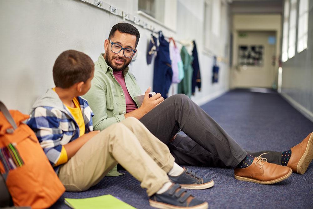 Teacher sitting on floor with child