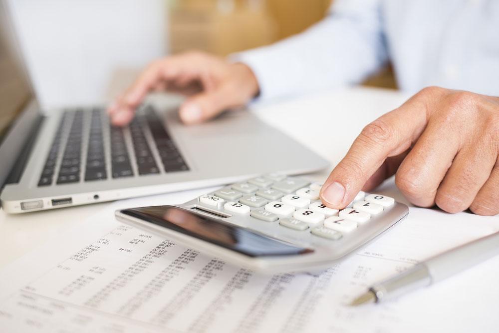 Man with calculator and laptop